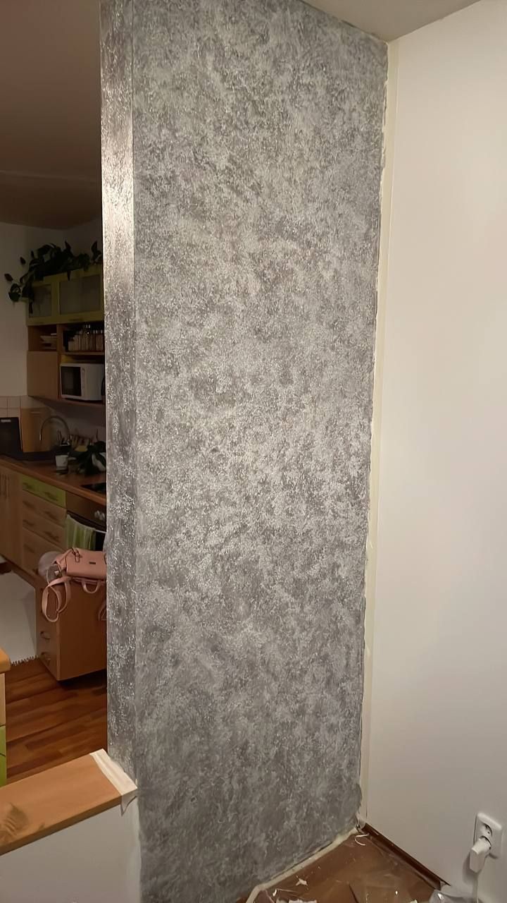 Metalická stříbrná stěrka na sloupu mezi kuchyní a obývákem